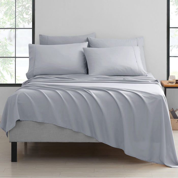 A silver 6-piece bamboo sheet set on a bed, with a fitted sheet, flat sheet, and pillowcases displayed in a bright room setting.
