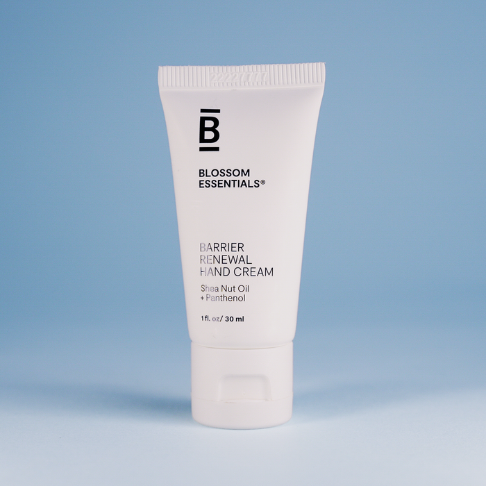 Tube of Blossom Essentials Barrier Renewal Hand Cream on a light blue background