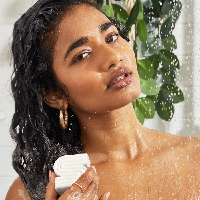 KITSCH Ultra Sensitive Solid Shampoo Bar in use — model lathering bar on hair in shower — bottle-free beauty format — gentle formula for sensitive scalps