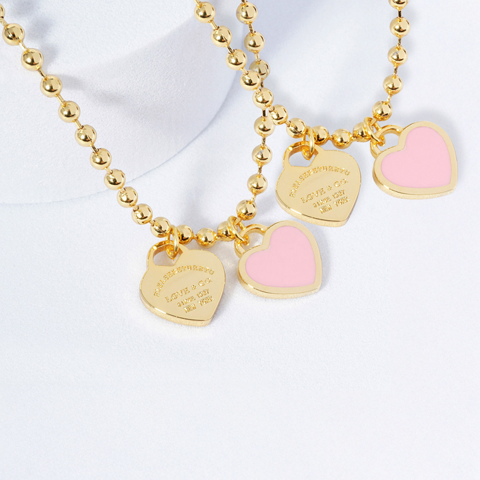 Gold necklace with heart-shaped pendants on a white background