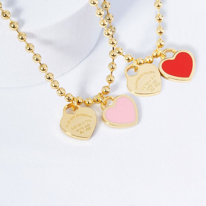 Gold necklace with heart-shaped charms on a white background