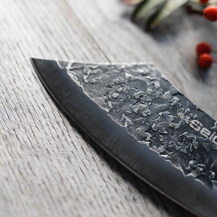 Serrated knife with floral patterns on a wooden surface