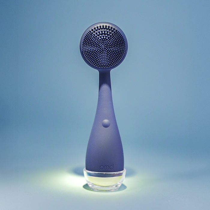 Purple handheld shower head with a clear base on a blue background